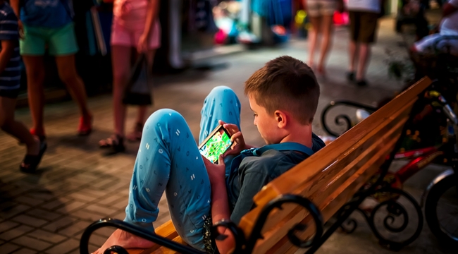 Carousel_boy-playing-games-on-his-smartphone-in-the-street-2023-11-27-05-28-51-utc
